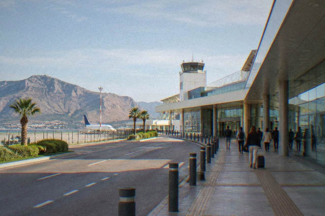 A passenger terminal building at Palermo Falcone Borsellino airport under a clear sky
