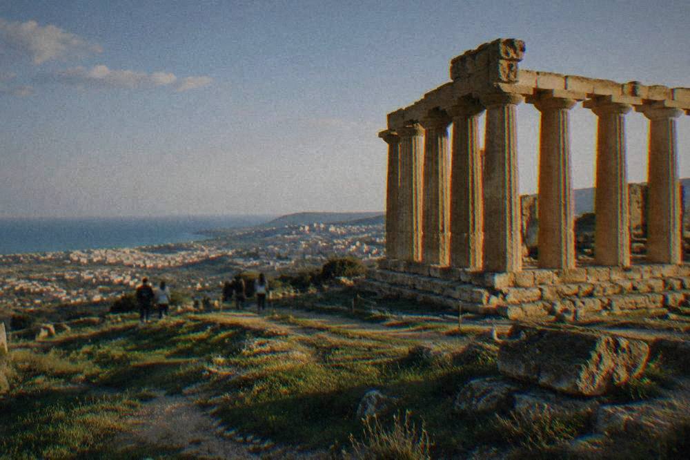 Doric temple columns standing on a grassy ridge above the town of Agrigento