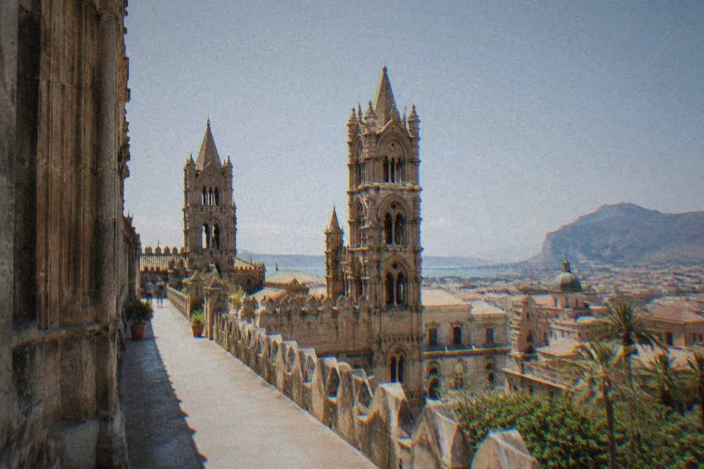 A view along the cathedral roof terrace toward the towers and the city rooftops of Palermo