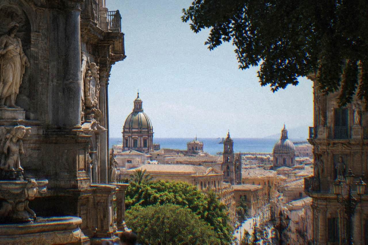 View over the domes and rooftops of central Palermo toward the sea on a bright morning