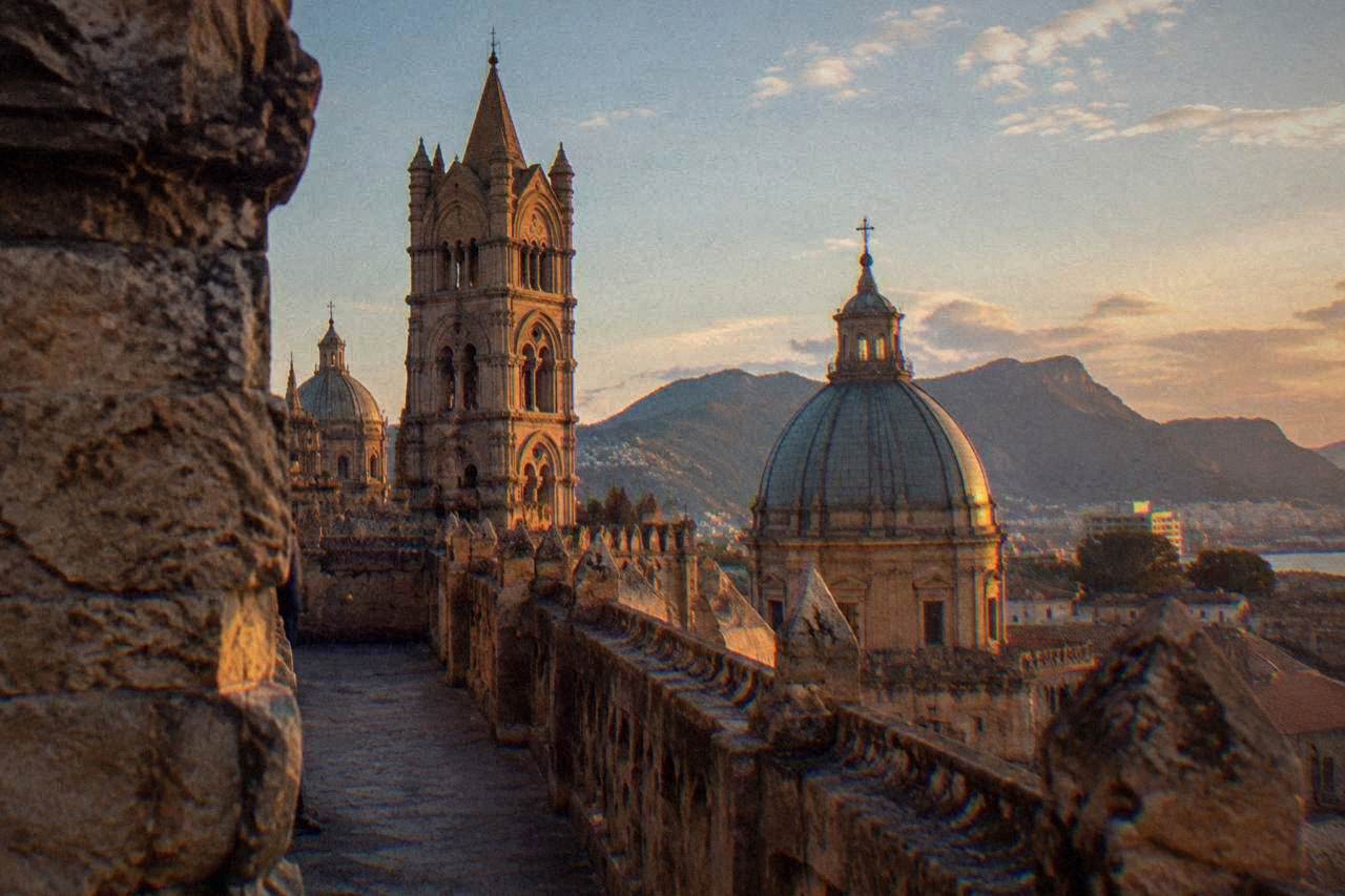 Walkway along the rooftop of Palermo Cathedral with carved parapets and domes under an open sky