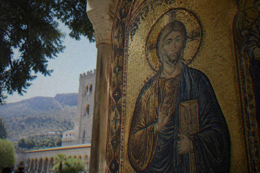 Close view of gold mosaic tesserae depicting a figure on the upper wall of Monreale Cathedral