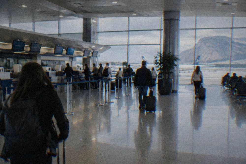 Departures hall at Palermo Falcone Borsellino airport with travellers and check-in desks