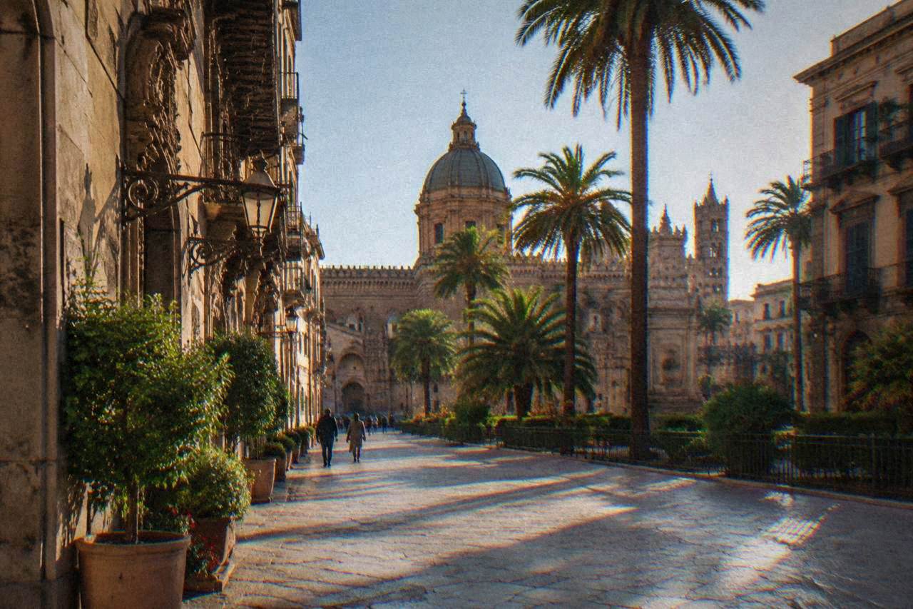 Sunlit Sicilian street with ornate buildings and palm trees in central Palermo