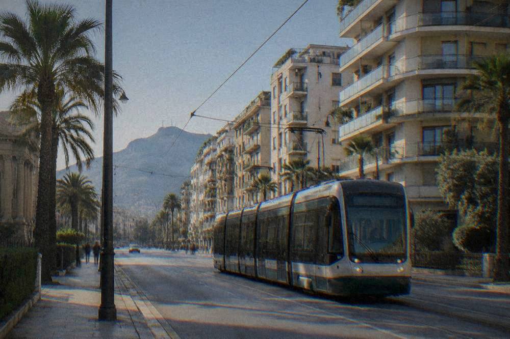A Palermo tram passing modern apartment buildings under a clear sky