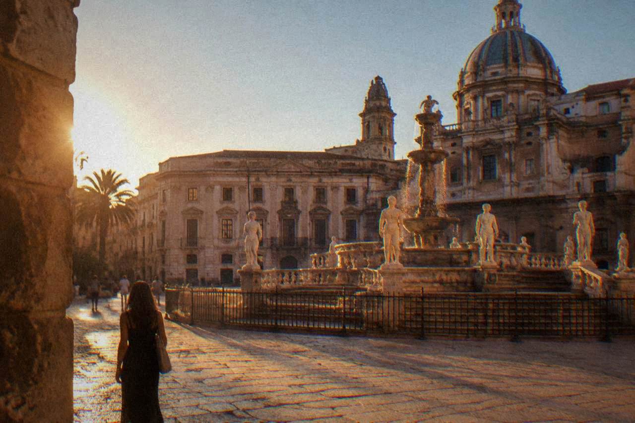 Sunlit square with baroque facades and a fountain in central Palermo