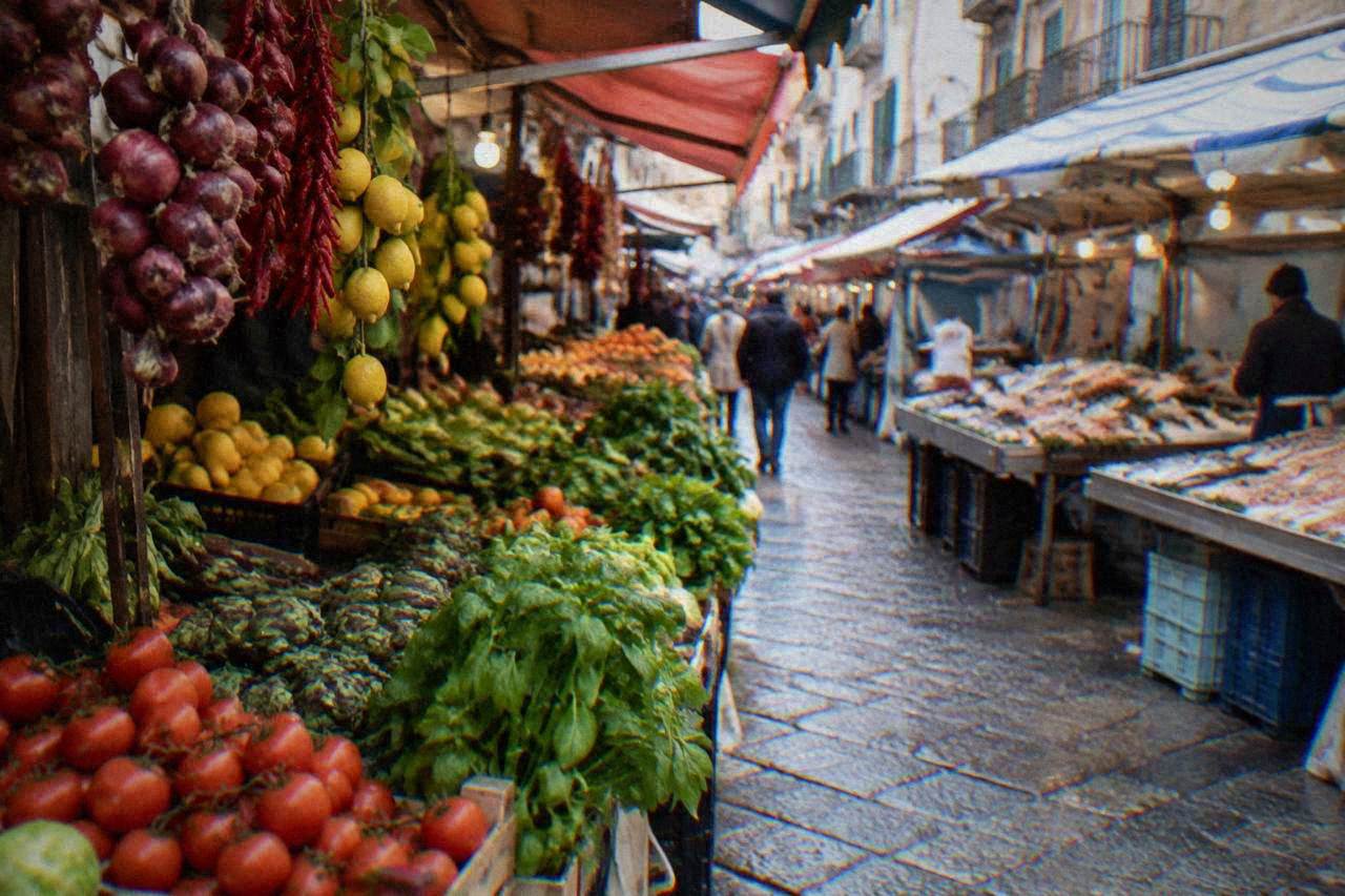 A busy Palermo market street with food stalls and hanging produce in daylight