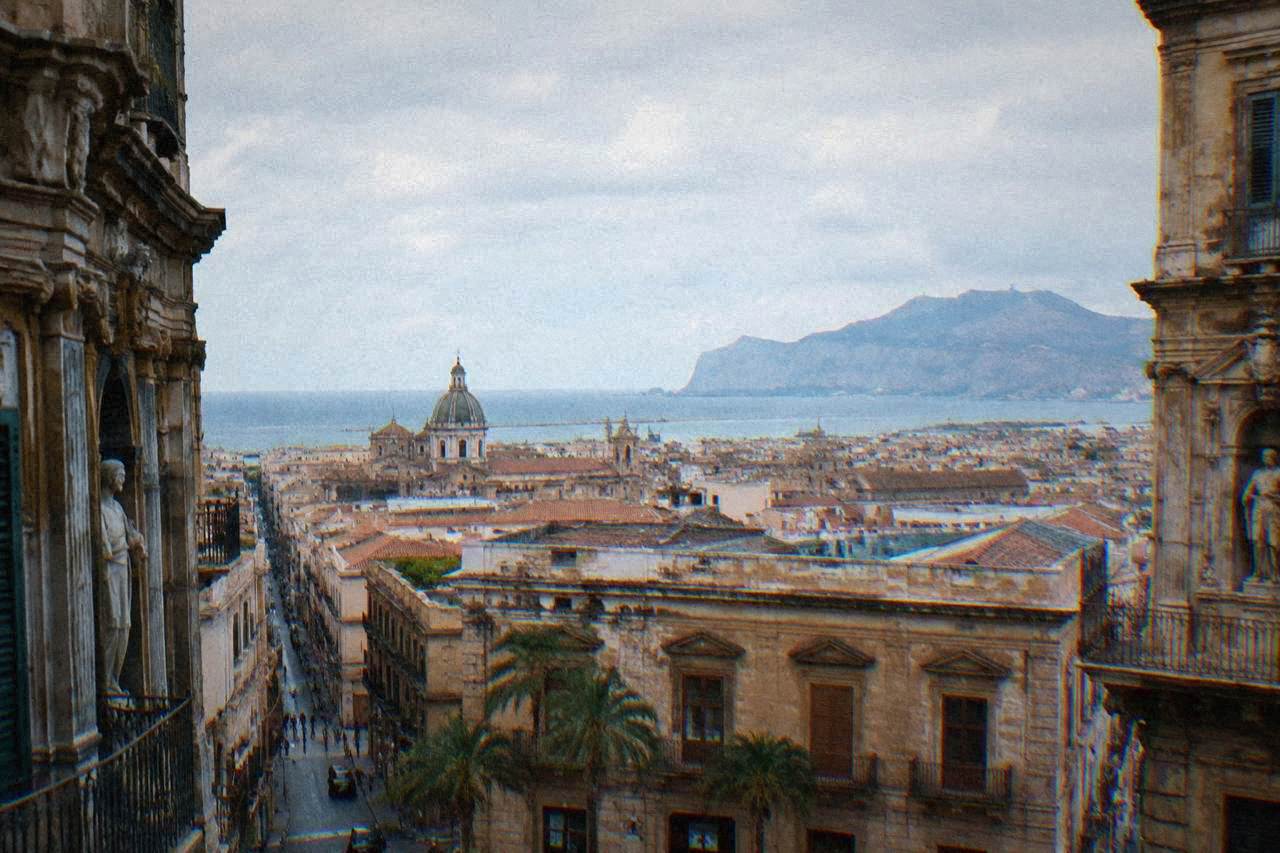 View over Palermo rooftops toward the Tyrrhenian Sea with mountains in the distance