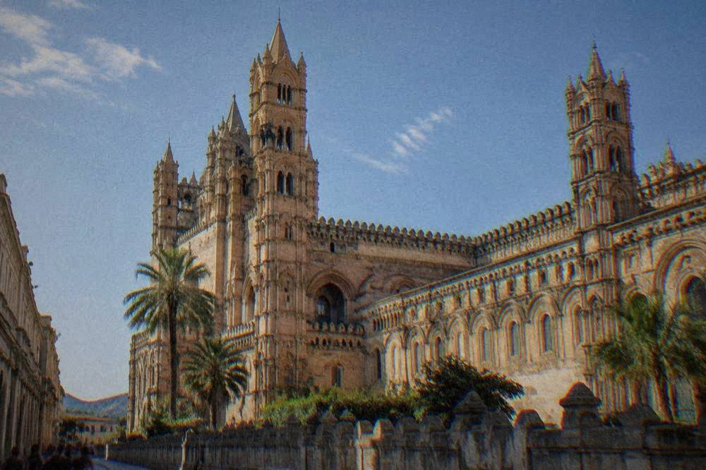 The exterior towers and arcaded wall of Palermo Cathedral seen from the street
