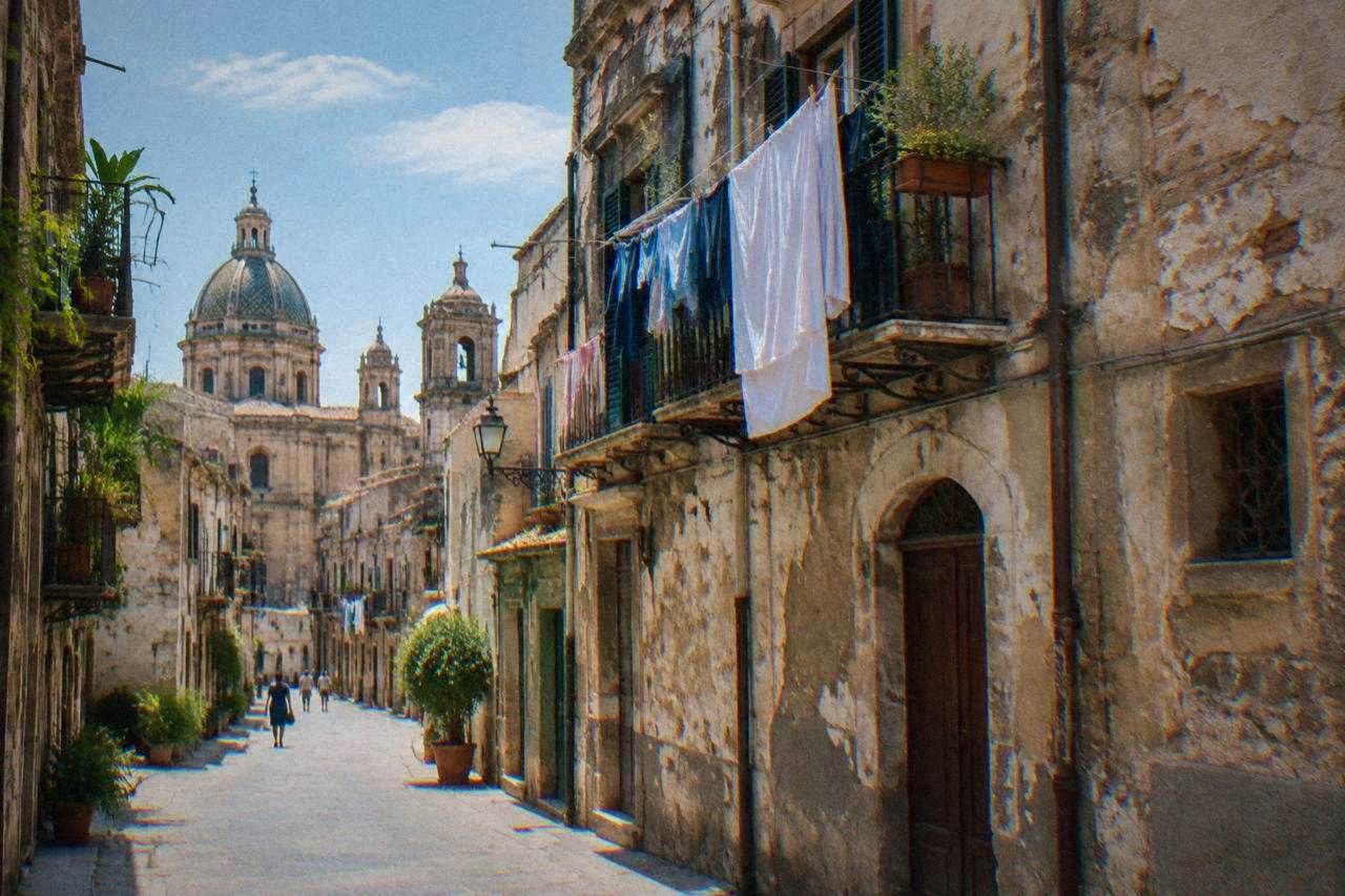 A faded Palermo street with worn plaster facades and hanging laundry in the historic centre