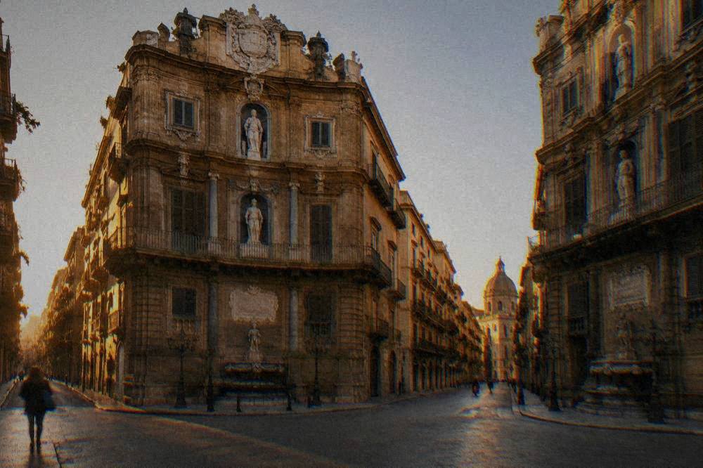 The corner facades of the Quattro Canti intersection in Palermo seen from street level