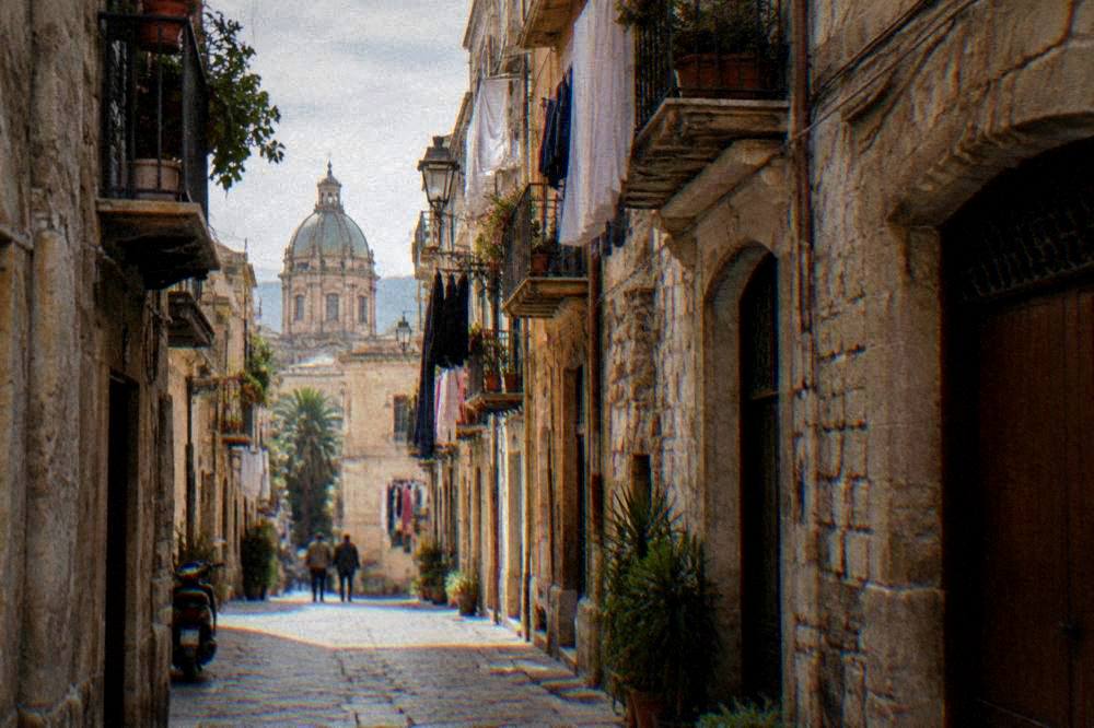 A narrow old lane in Palermo with stone buildings, balconies and laundry above