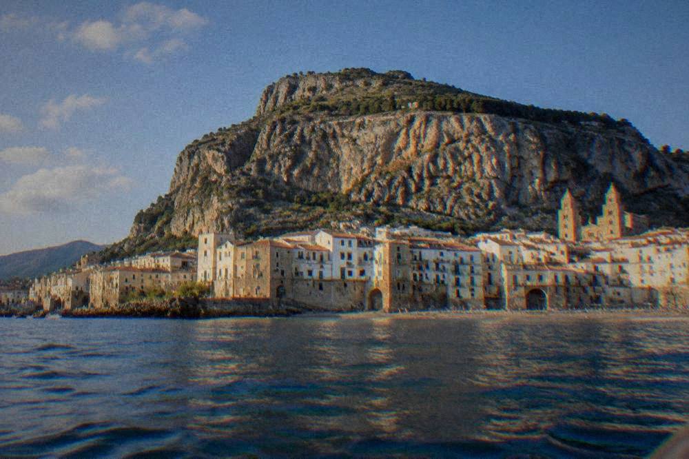 The coastal town of Cefalu seen from the water with its rocky promontory