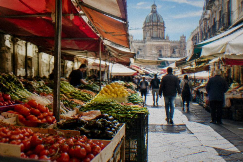 Busy market street in the BallarÃ² district with produce stalls under awnings