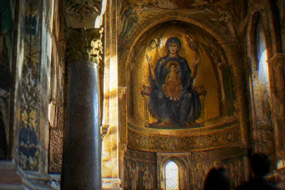 Golden mosaic detail of the Palatine Chapel apse with a figure in a blue mantle