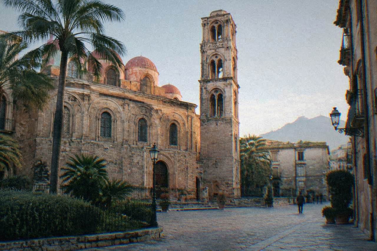 Church facade and bell tower beside a small square in central Palermo