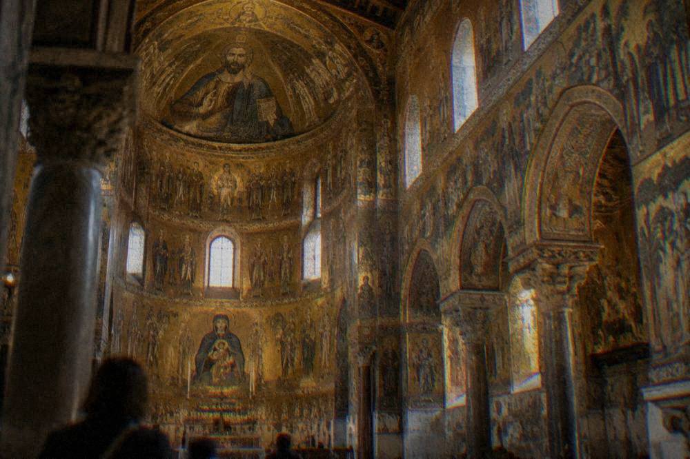 Interior of a church with gold mosaic decoration covering the walls and dome