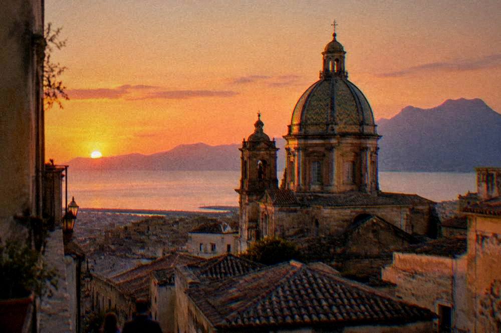 Evening light on a church dome above rooftops in an old city
