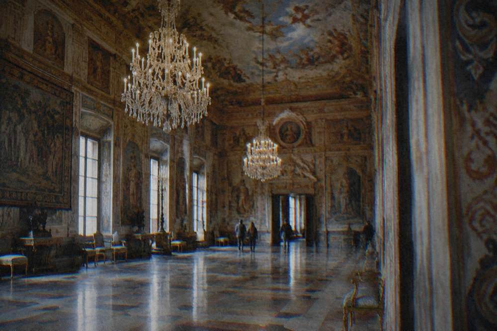 A grand hall with chandeliers and frescoed ceilings inside a Sicilian palace