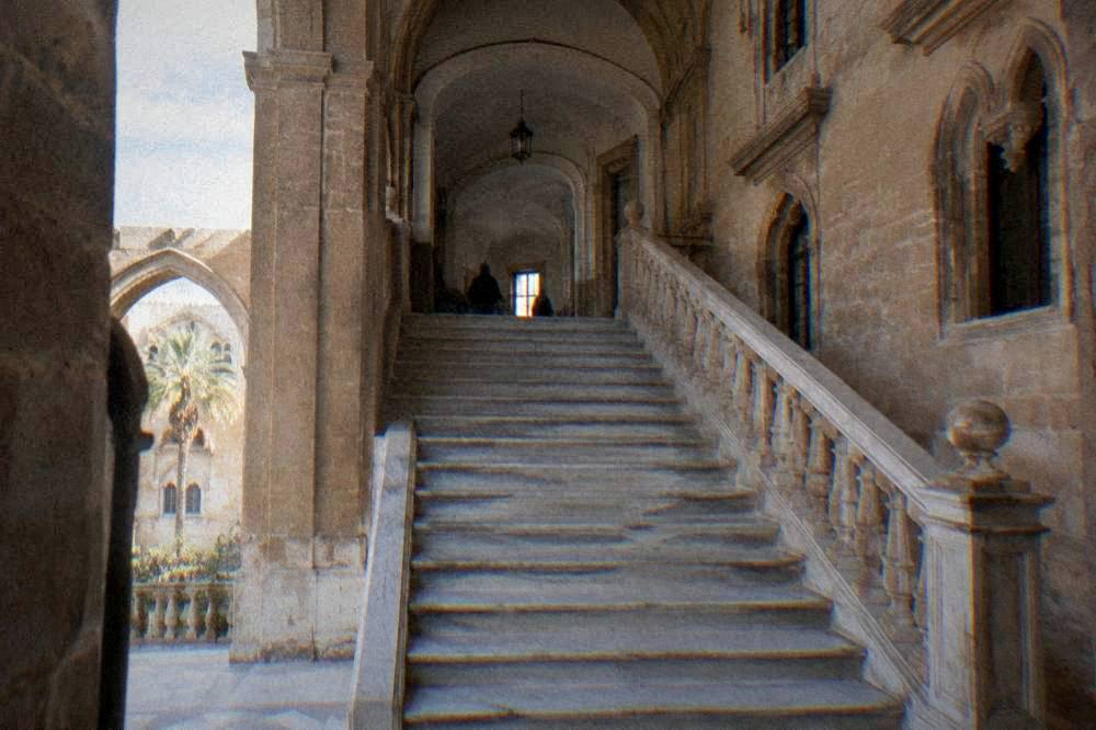 A marble staircase and archway connecting palace rooms in Palermo