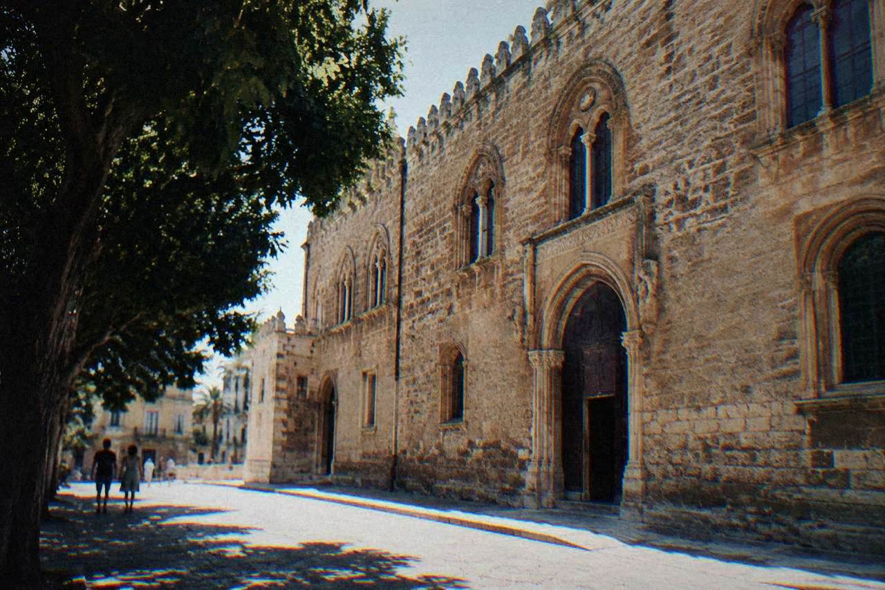 A historic stone palace facade on a quiet street in the Kalsa quarter of Palermo