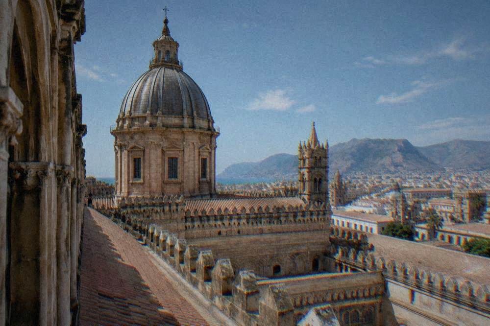 A view along the cathedral roofline toward the dome and the city beyond