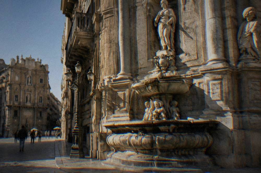 A close view of one Quattro Canti corner with its tiered fountain and statues in Palermo