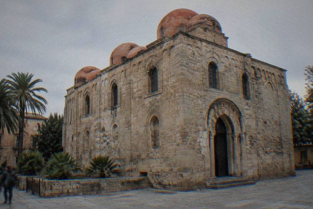 The plain stone facade and arched doorway of San Cataldo Church in Palermo