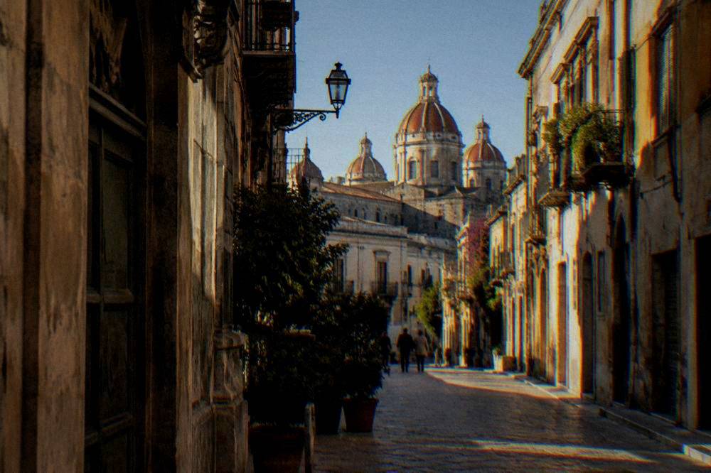 A street in the old centre of Palermo with San Cataldo's domes visible above the rooftops