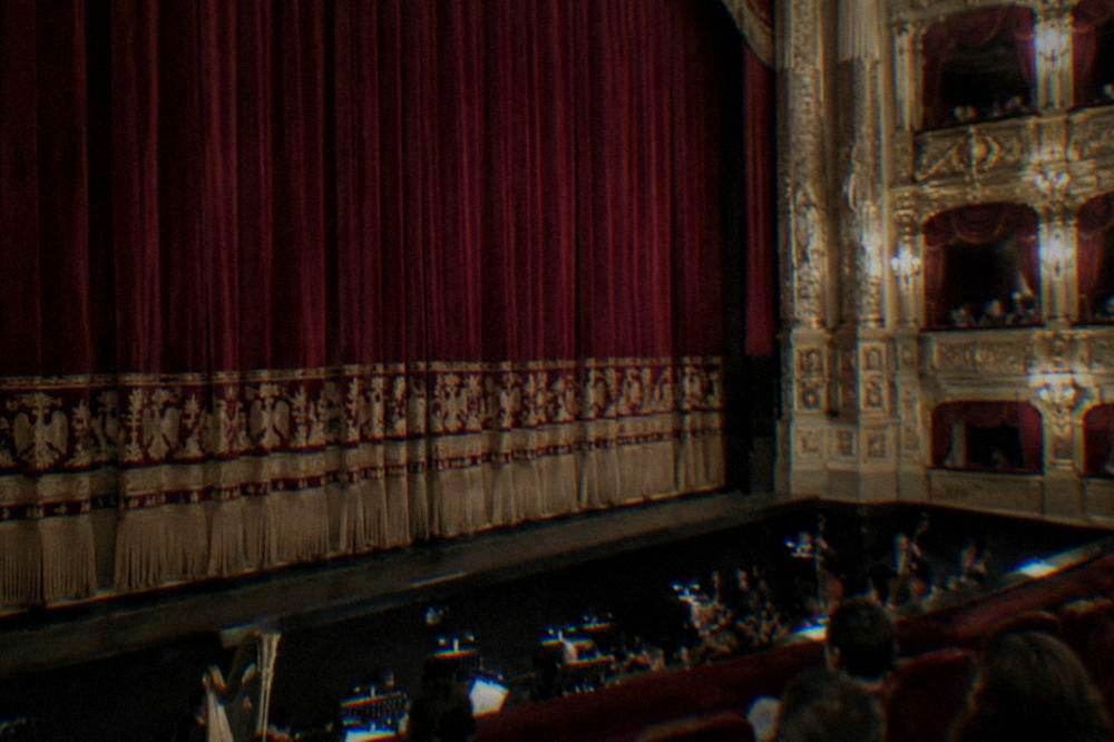 A close view of the stage curtain and orchestra pit inside the opera house