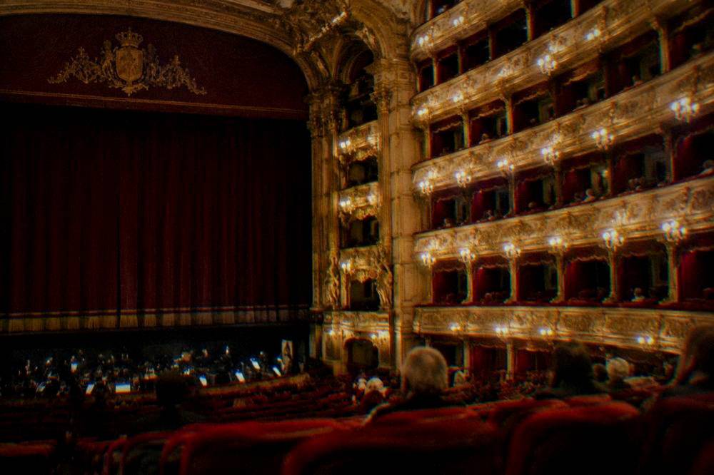 Ornate gilded boxes and balconies rising in tiers inside the opera house auditorium