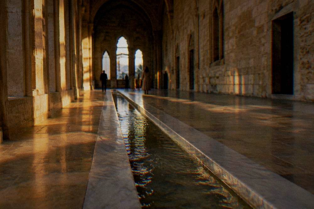A water channel inlaid in the stone floor of a long hall, marble in bands along the edges