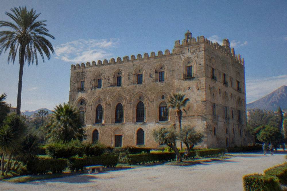 A wide view of the Zisa Palace facade with its arched windows and crenellated roofline
