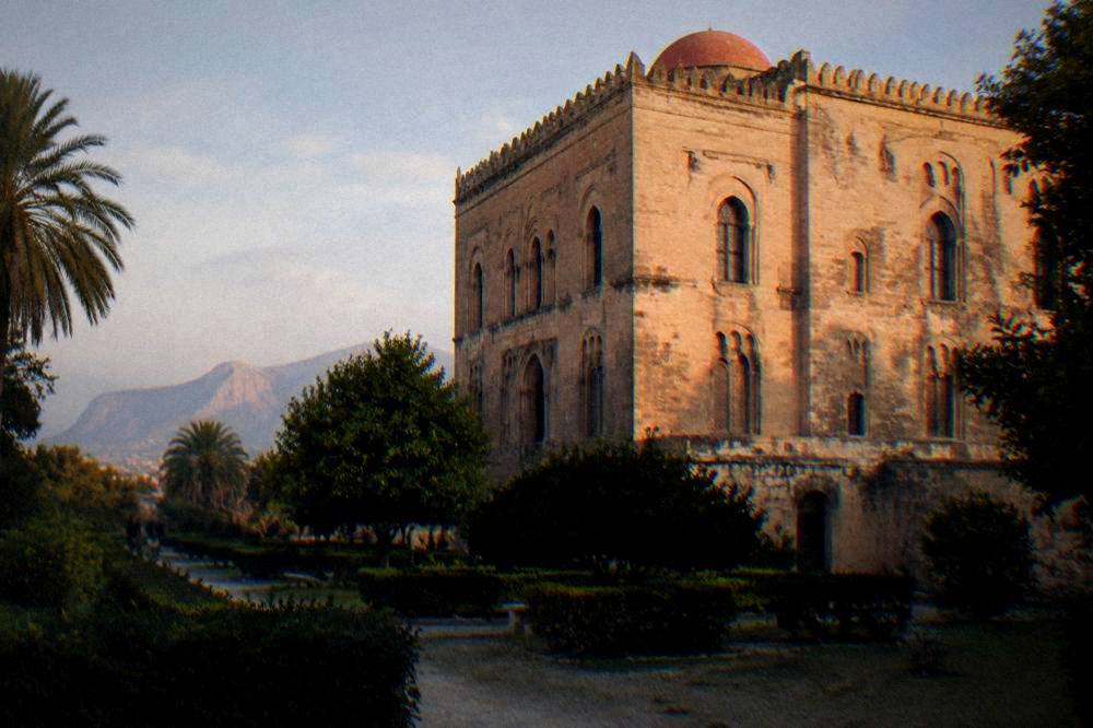 Late afternoon light on the stone walls of the Zisa Palace with the garden in shadow