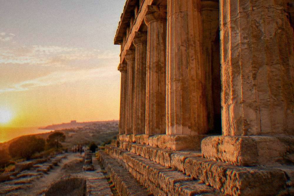 Row of columns along a restored ancient temple at golden hour