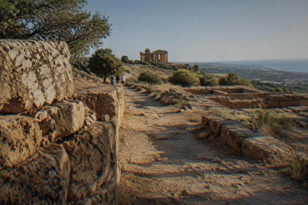 Ancient stone wall and temple foundations on a dry hillside path