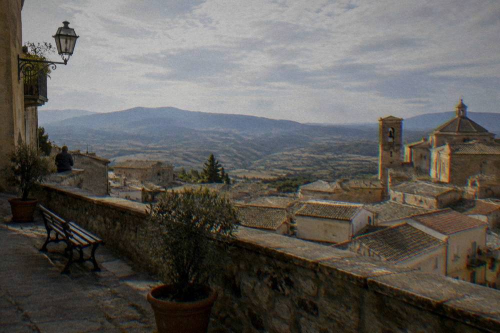 A view over tiled rooftops and countryside from a hilltop terrace in an inland Sicilian town
