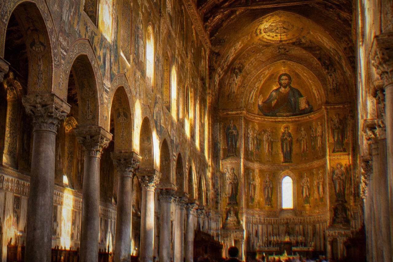 The golden interior of Monreale Cathedral with its mosaic figures rising above the nave