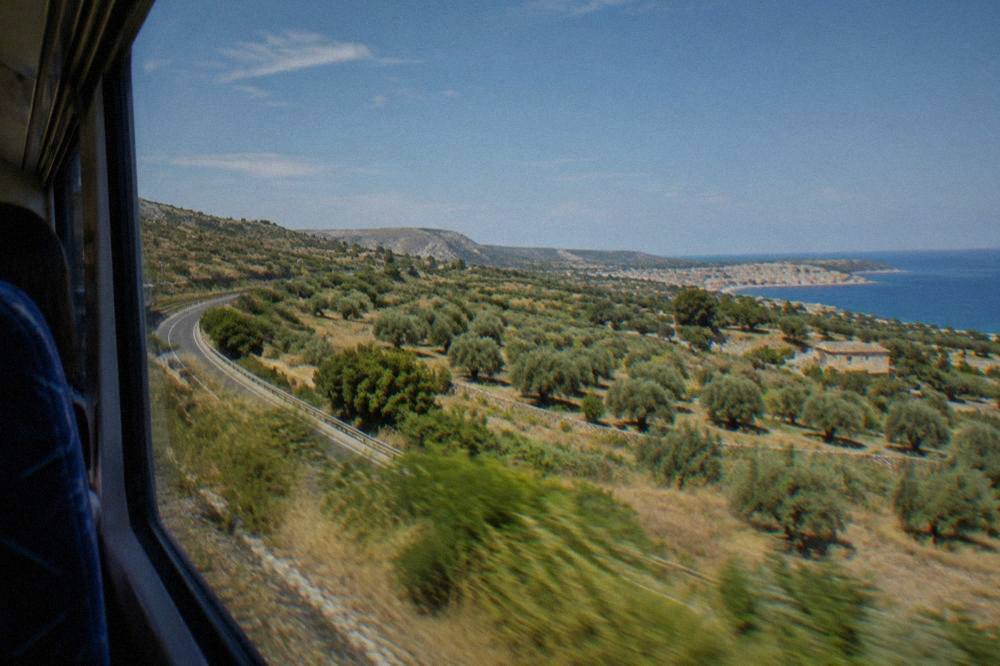 A long coach and rail journey across Sicilian countryside with hills and olive groves