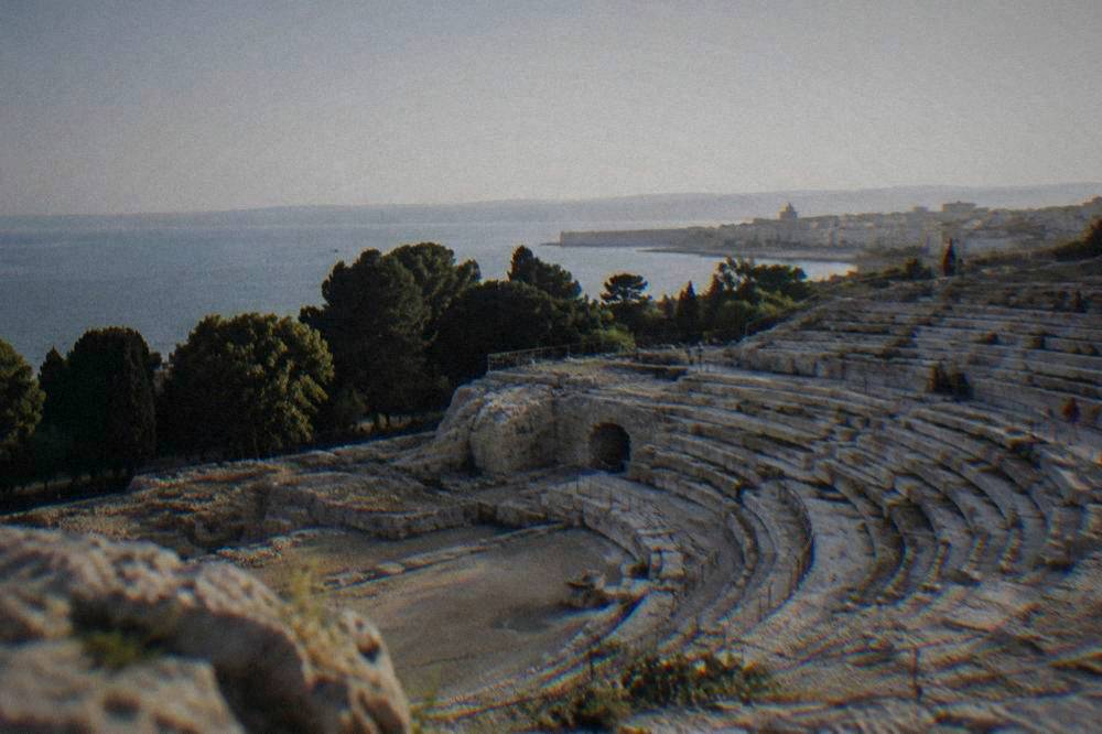 Rows of stone seats carved into a hillside in an ancient open-air theatre
