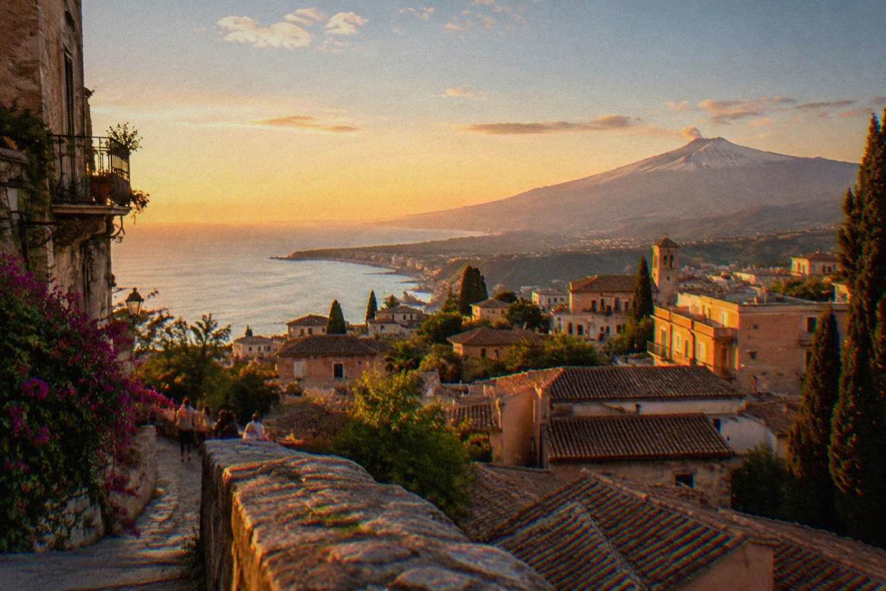 View over Taormina rooftops toward the sea and the slopes of Mount Etna in the distance