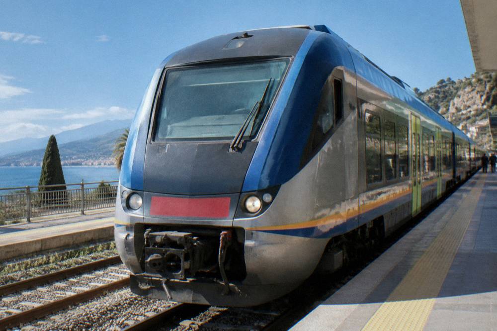Regional train at a Sicilian station platform in morning light