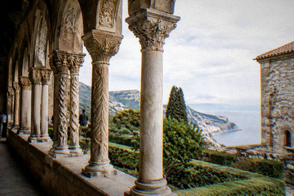 Cloister arches with carved columns at Monreale under bright sky