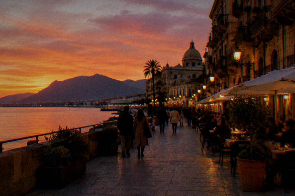 An evening street in Palermo with lit restaurants and people walking in autumn