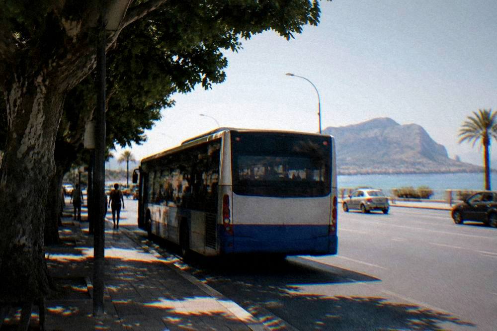 An AMAT bus at a stop on the road toward Mondello with the sea in the distance