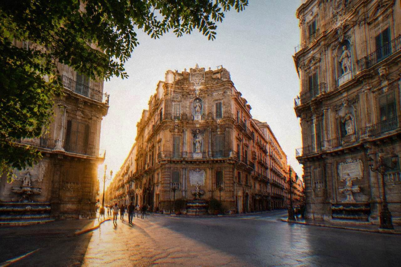 The four corner facades of the Quattro Canti crossing in Palermo at golden hour
