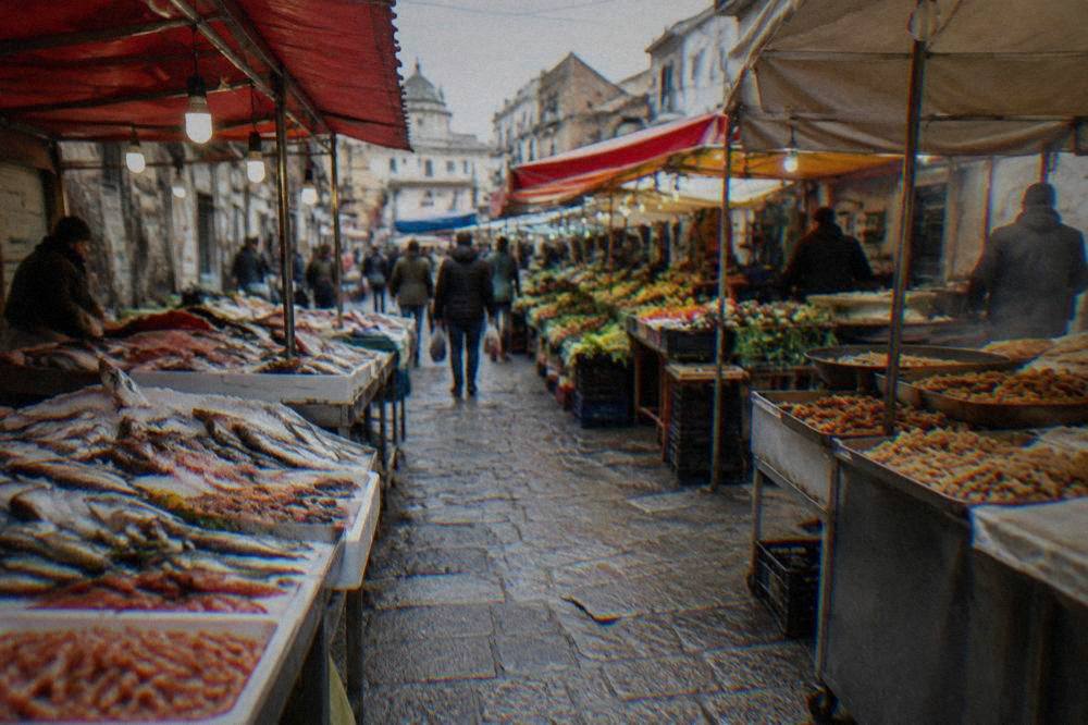 A busy Palermo market lane with stalls of vegetables, fish and fried food under awnings