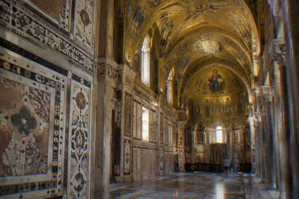 The interior of the Cappella Palatina with gold mosaic ceilings and inlaid marble walls