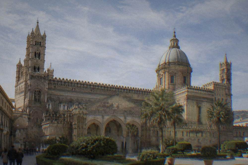 The front of Palermo Cathedral with its towers and pointed decoration under a clear sky