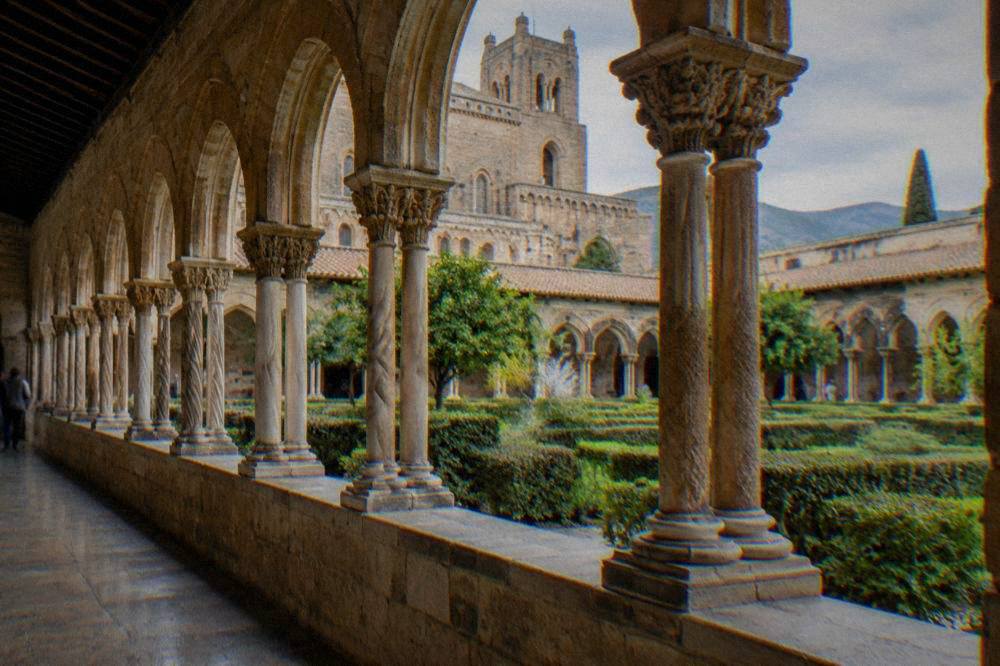 The cloister of Monreale cathedral with paired columns and arches around a garden